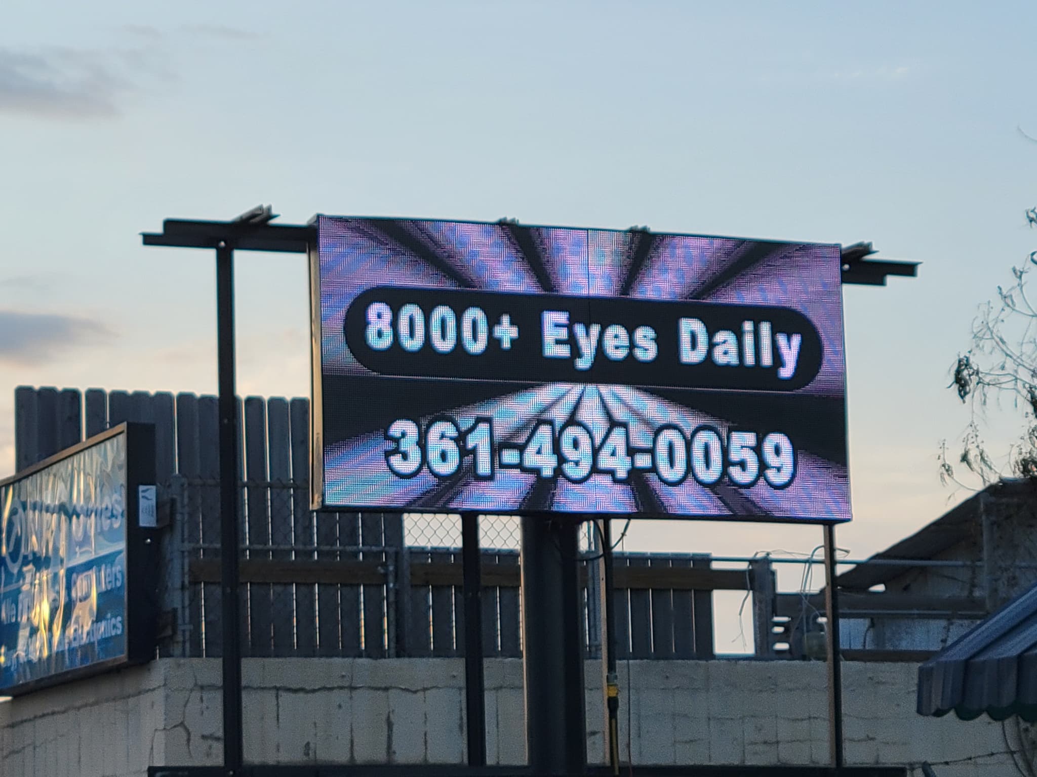 The NPC LED sign on Main showing ‘8000+ Eyes Daily’ and a phone number
